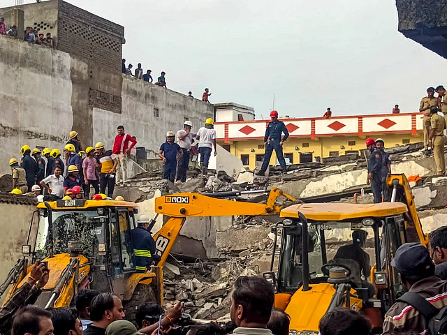 Officials and others during a rescue operation after a building collapse, in Surat district, Saturday, July 6, 2024. 