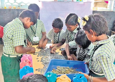 Students counting the money collected from their piggy banks at Adi Dravidar Welfare Primary School in PK Agaram