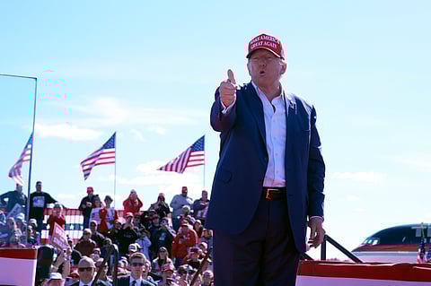 Republican presidential nominee former President Donald Trump gestures as he departs a campaign event at Central Wisconsin Airport.