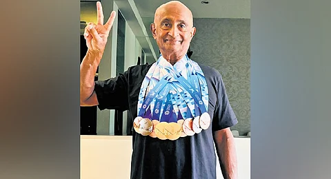 Kurian posing with the medals he won at the World Masters Games 2025