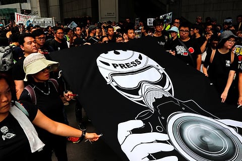 Journalists and supporters for press freedom wear black as they stage a silent march to Police Headquarters to denounce media treatment during protest against a proposed extradition bill, in Hong Kong, China July 14, 2019.  (RFA)