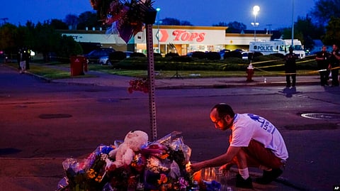 A person pays his respects at a makeshift memorial outside the scene of a shooting at a supermarket in Buffalo, NY, May 15, 2022.