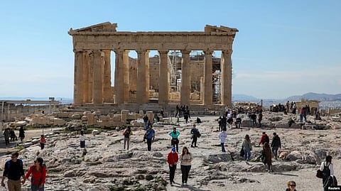 People visit the ancient Parthenon Temple atop the Acropolis hill archaeological site in Athens, Greece, Feb. 26, 2022. (Reuters via VOA)