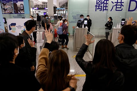 The Lai family, who are emigrating to Scotland, wave goodbye to their friends who are seeing them off before their departure at Hong Kong International Airport in Hong Kong, China, December 17, 2020. 