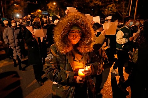 Protesters hold up blank sheets of paper and chant slogans as they march in protest against strict anti-COVID measures in Beijing, Nov. 27, 2022. "Chinese people overseas owe a huge debt to the young people inside the Great Firewall who took part in the white paper movement," says a Chinese student. (AP)