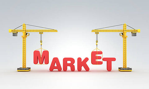 Illustration of two yellow cranes lifting large red letters to form the word “MARKET.”