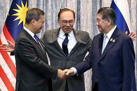 Malaysia's Prime Minister Anwar Ibrahim stands with Cambodia's Prime Minister Hun Manet and Thailand's acting Prime Minister Phumtham Wechayachai as they shake hands at a press conference regarding a ceasefire for Thailand–Cambodia border conflict, in Putrajaya, Malaysia, July 28, 2025. (Mohd Rasfan/via Reuters)
