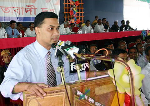 The image shows Acting General Secretary Tarique Rahman addressing a gathering, with several leaders seated behind him listening.