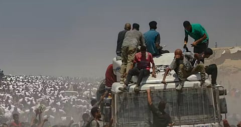 in the image many people are shown running there is a car and people are climbing trying to get on