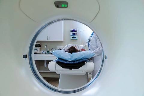 In the image the scene of hospital is shown with the patient going in the CT Scan machine