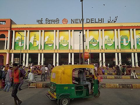 In the image New Delhi railway station is shown with crowd outside it 