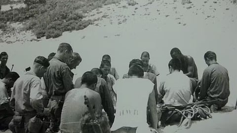 Japanese and American troops kneel in prayer on the island of Aka, June 1945. 