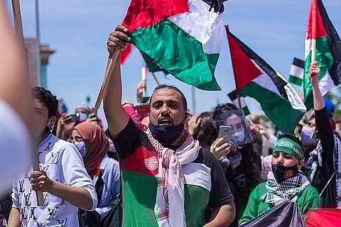 people marching with palestinian flags
