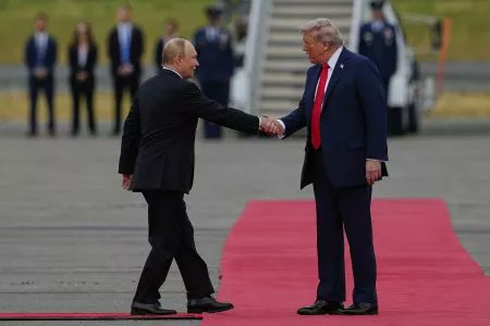 President Trump and Putin shaking hands on red carpet.