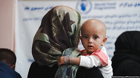 An Afghani woman holding her child in arms. 
