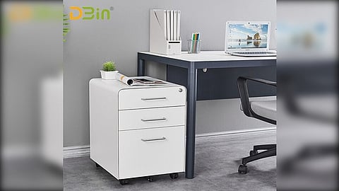 A graphical illustration of office cubicle having desk ,chair drawer ,files and laptop on desk.