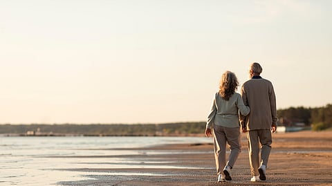 An elder couple walking by beach.