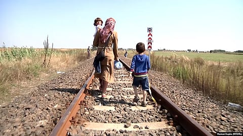 A mother and her children, pictured in 2015, walk across the border from Serbia to Hungary.