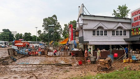 Jammu: Workers clean mud and debris from their shops after floodwaters entered due to flash floods in the Chakki River in Jammu on Wednesday, August 27, 2025.