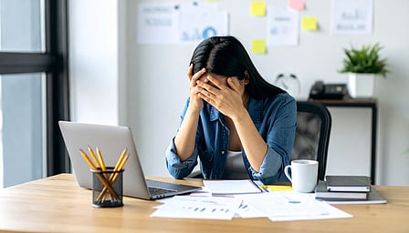 Woman sitting and holding her forehead