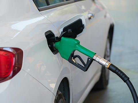 Filling E20 Petrol in the Tank of a White Sedan