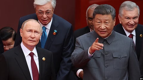 Russian President Vladimir Putin speaks with Chinese leader Xi Jinping before a military parade on Beijing's Tiananmen Square on September 3.