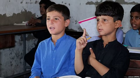 Afghan refugee children attend lessons at the refugee camp where they live near Peshawar, Pakistan.
