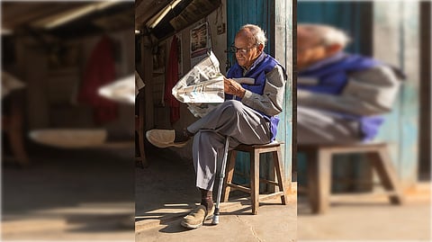 old man reading paper