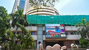  Mumbai: People walk past a screen showing stock market goes down outside BSE building at Dalal Street after the counting of votes for Lok Sabha polls, in Mumbai on Tuesday, June 4, 2024
