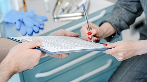 Image of woman signing insurance.