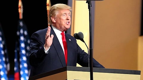 Donald Trump giving speech to the people standing in a podium