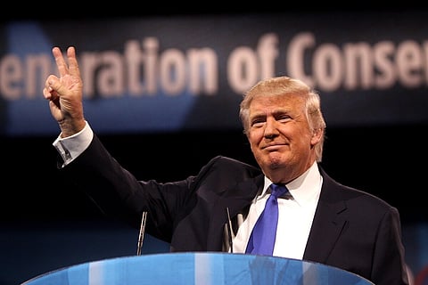 Image of trump showing peace sign at the 2013 Conservative Political Action Conference (CPAC) in National Harbor, Maryland.