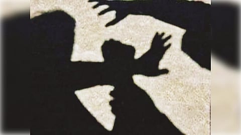 Shadow silhouette of two figures on a textured surface, depicting one figure appearing to shield against an approaching, aggressive form. Emotive and tense.