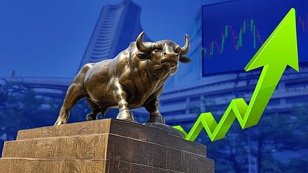 Bronze bull statue on a stone pedestal with a green upward arrow symbolizing market growth. Stock chart in the background on a blue backdrop.