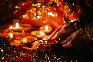 Image of a woman's hand and the diya decoration for the festivals of light