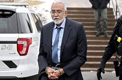 Subu Vedam in handcuffs wearing a suit