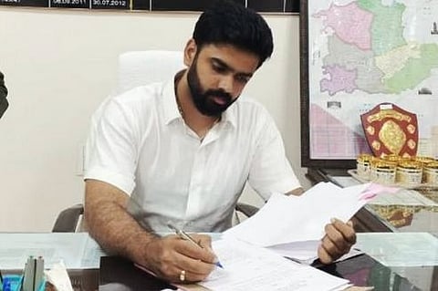 IAS Gowda working, sigining documents