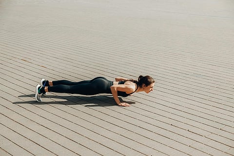 Image of a woman doing bodyweight training in a aesthetic background.
