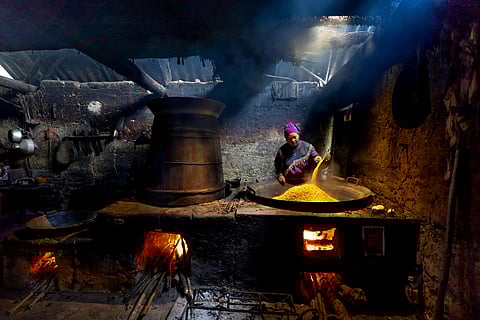 Woman Preparing Cereal on Old Furnace
