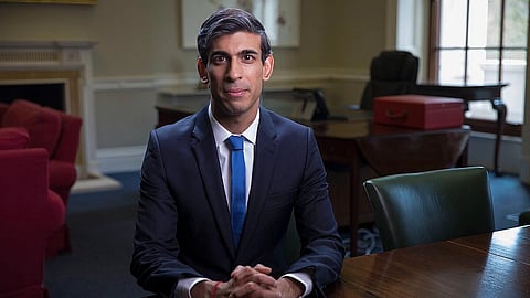 Rishi Sunak sitting in the office wearing blue coat formal dress