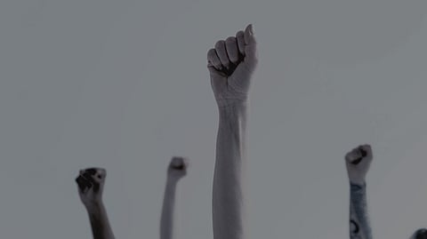 Fists of people with plane background representing protest