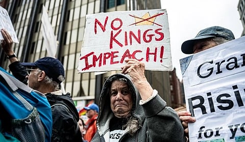 In the image protesters are shown with their banners and posters to fight against trump. In one banner with red colour "No Kings Impeach!" is written and a crown is make with a cross