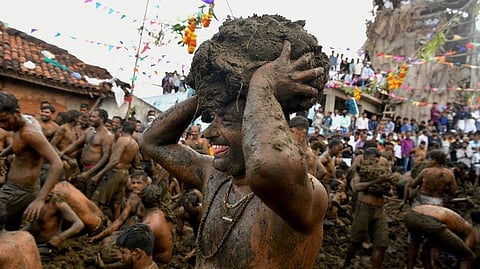 People are half naked in karnataka and tamil nadu border with cow dung on their body and faces someone is holding it in his head