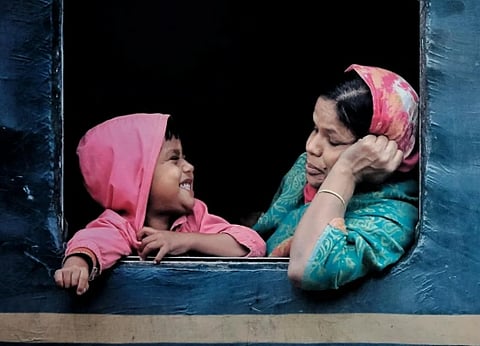 Image of a mother looking at her child who is smiling at her.