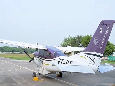 A white-and-purple cloud seeding plane on a runway.