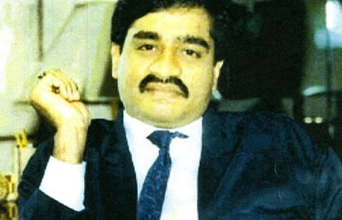 Old Image of Dawood Ibrahim in his blue suit and tie with his right hand slightly raised. 
