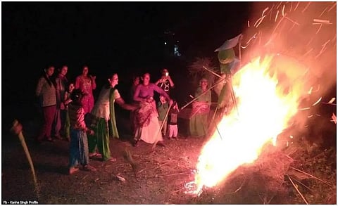 Women and children throwing items into a bonfire while celebrating Khatarua.