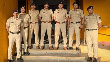In the image police officers are shown standing in stairs in front of police station