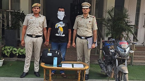 In the image two police officers are shown with a criminal standing in between with his face covered