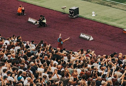 Image of live audience cheering in a football stadium during a LIVE match